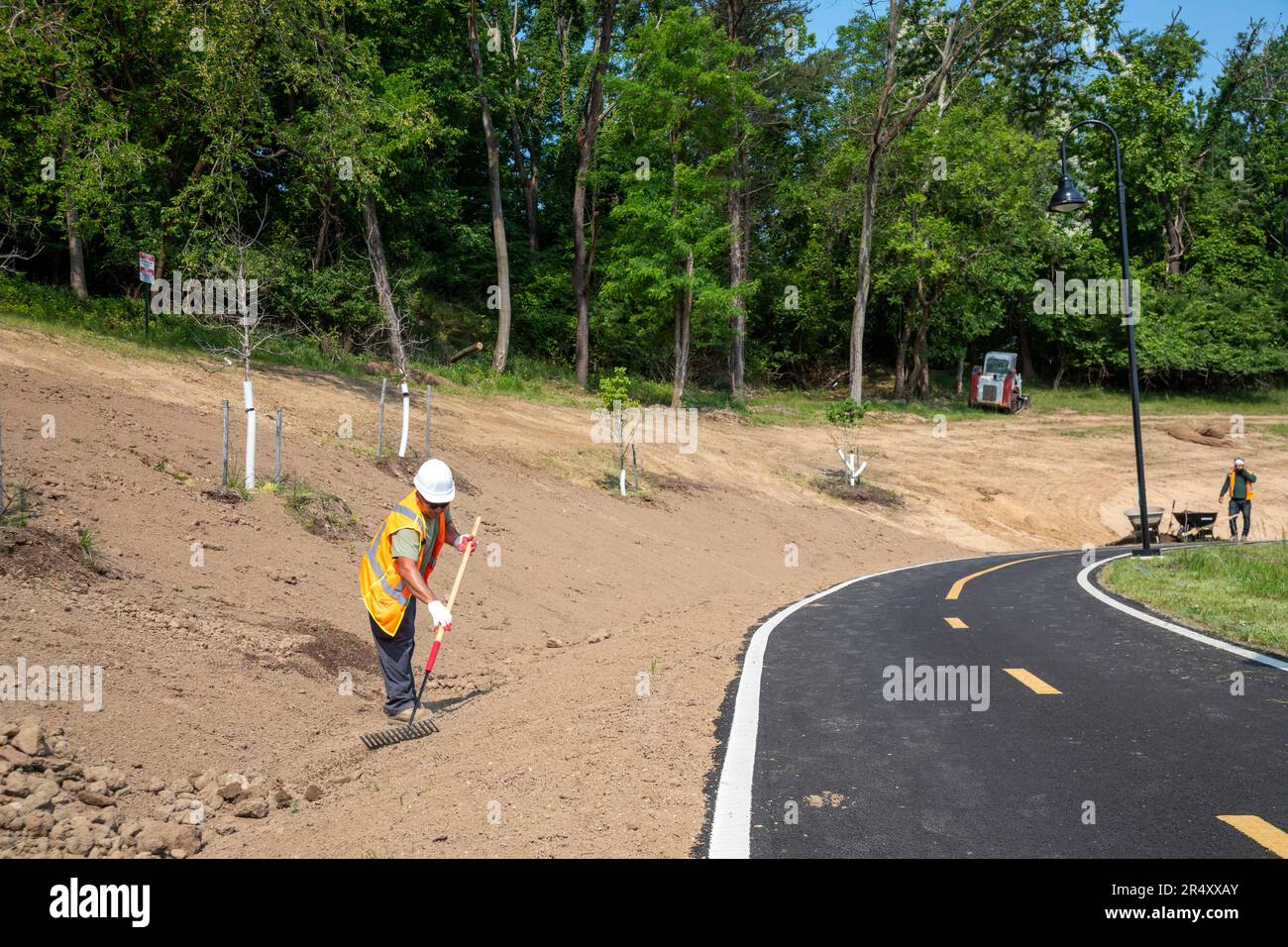 Washington, DC - A worker finishes landscaping along a new section of the Metropolitan Branch Trail, a biking/walking trail that runs from Union Stati Stock Photo