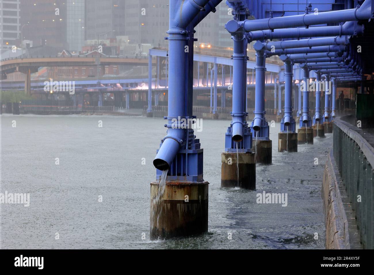 Wet weather discharge pipes funnel FDR highway runoff and pollution including 6PPD-quinone into the East River during a rain storm in New York City. Stock Photo