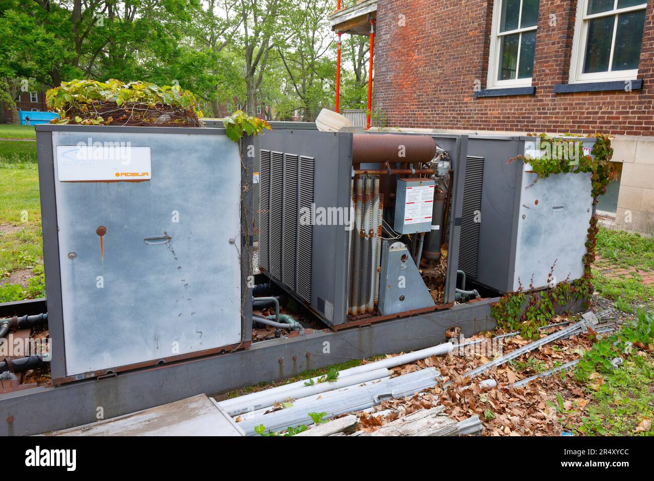 Defunct, out of service, Servel by Robur gas powered air conditioners, or absorption heat pumps, with ivy growing on top at Governors Island, New York Stock Photo