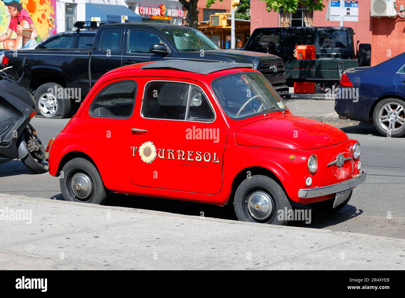 A Vintage Fiat 500 red car with Tournesol Bistro Francais marked on the doors. Stock Photo