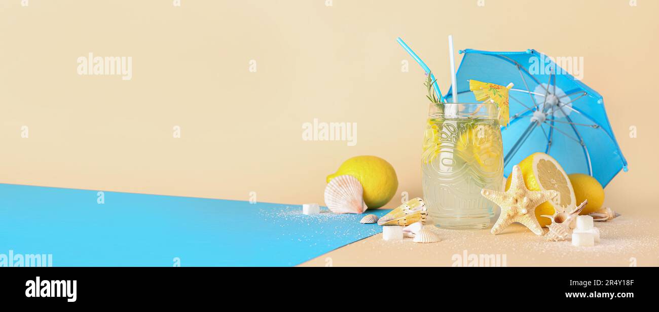 Glass of fresh lemonade, umbrella, lemons, sugar and sea shells on