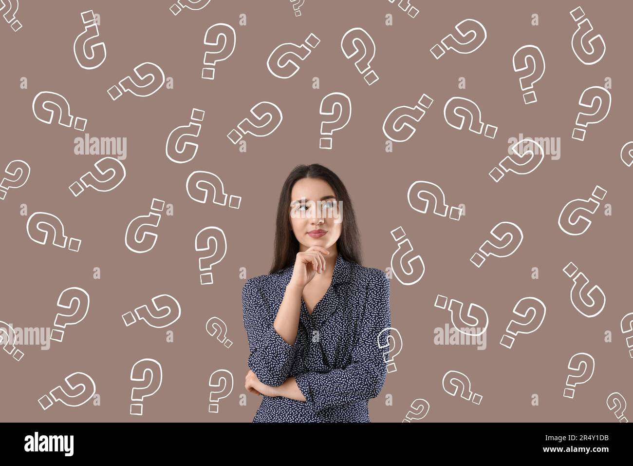 Thoughtful young woman with drawn question marks on brown background ...