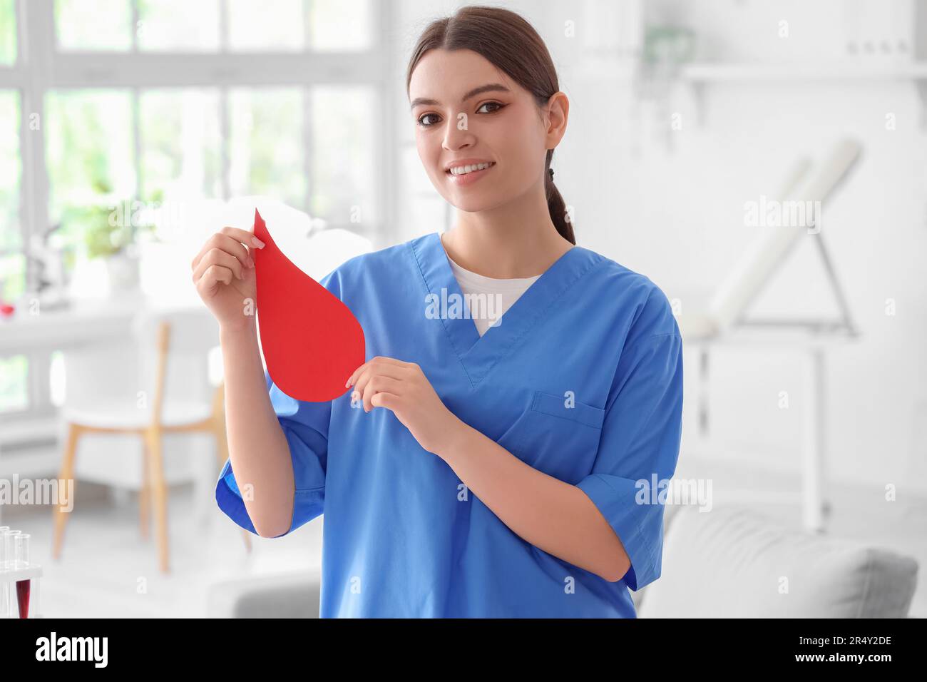 Female nurse with paper blood drop in clinic Stock Photo - Alamy