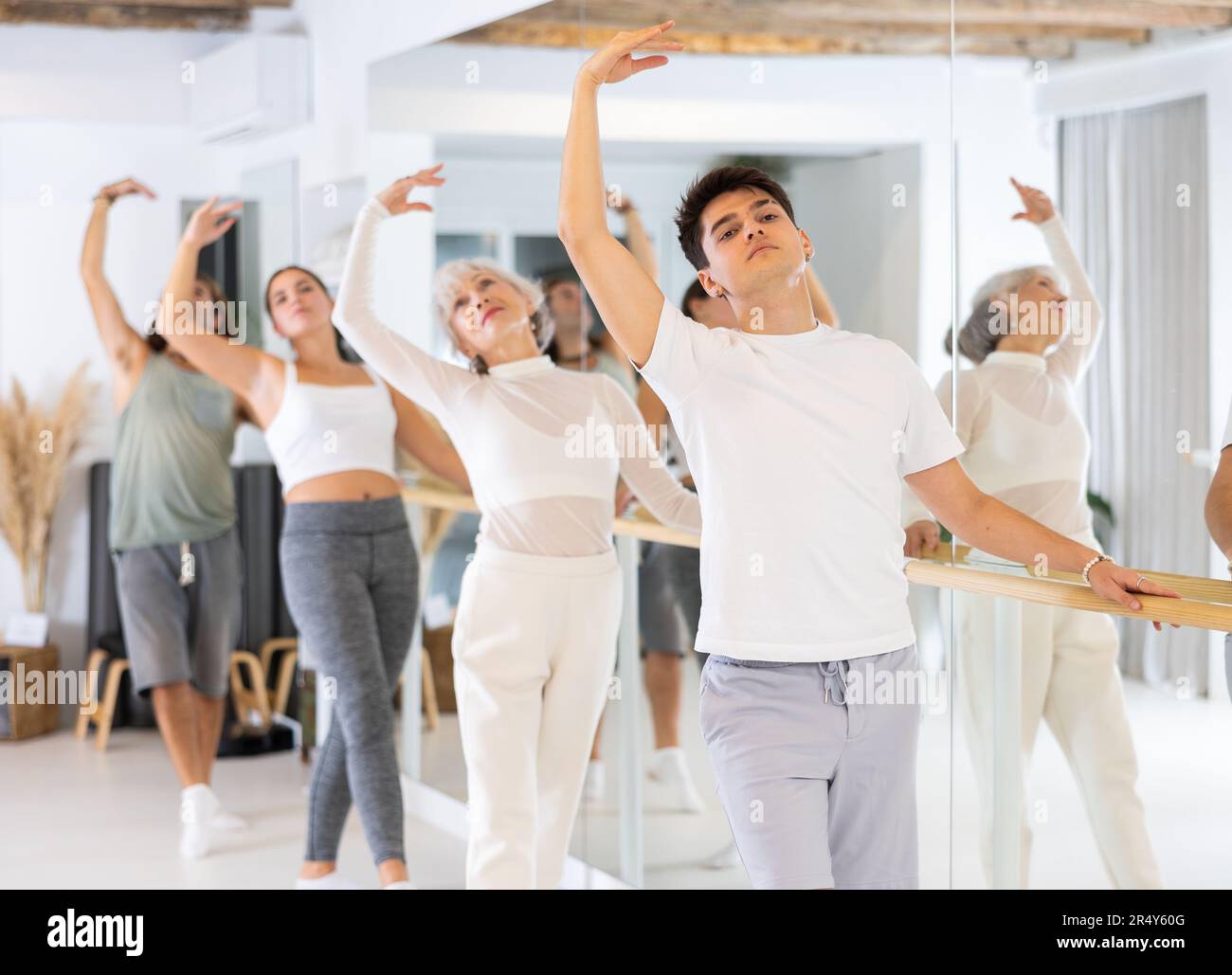 Diligent young man doing choreography at ballet barre Stock Photo