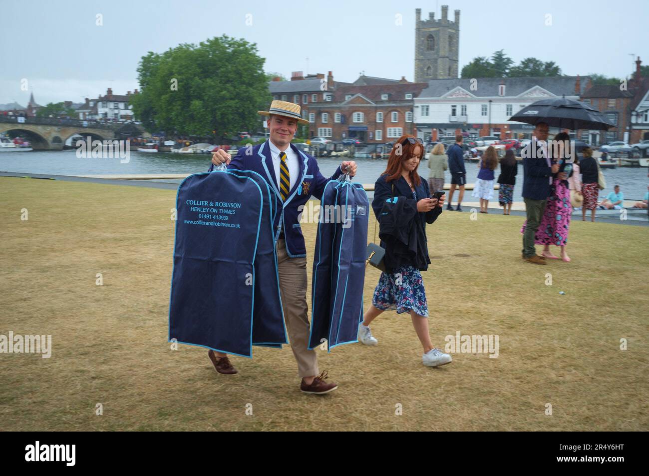A man in rowing attire carrying dry cleaned jackets  at Henley Royal Regatta, Henley-on-Thames, 2022 Stock Photo