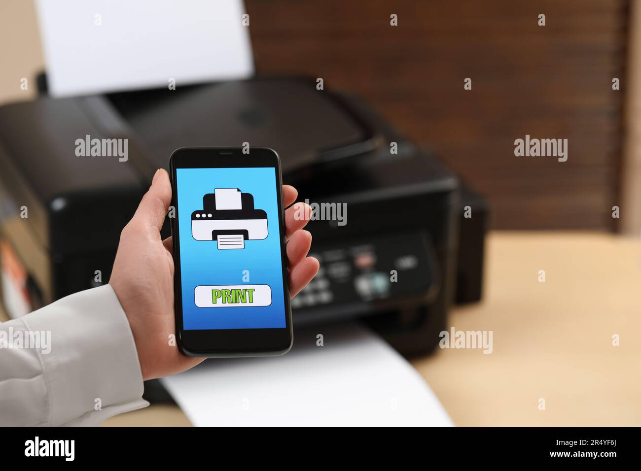 Man using printer management application on mobile phone indoors