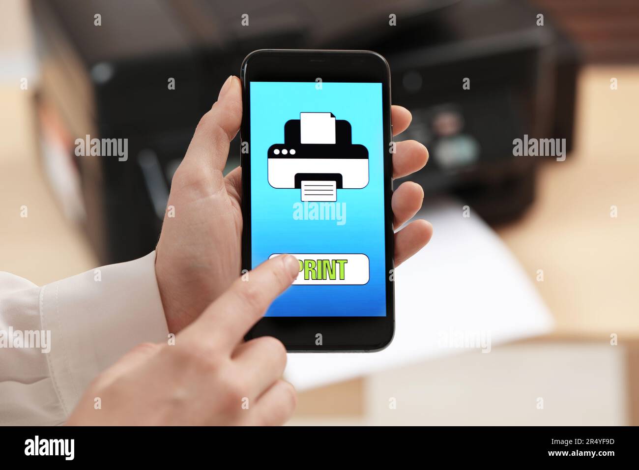 Man using printer management application on mobile phone indoors, closeup. Image on device screen. Stock Photo