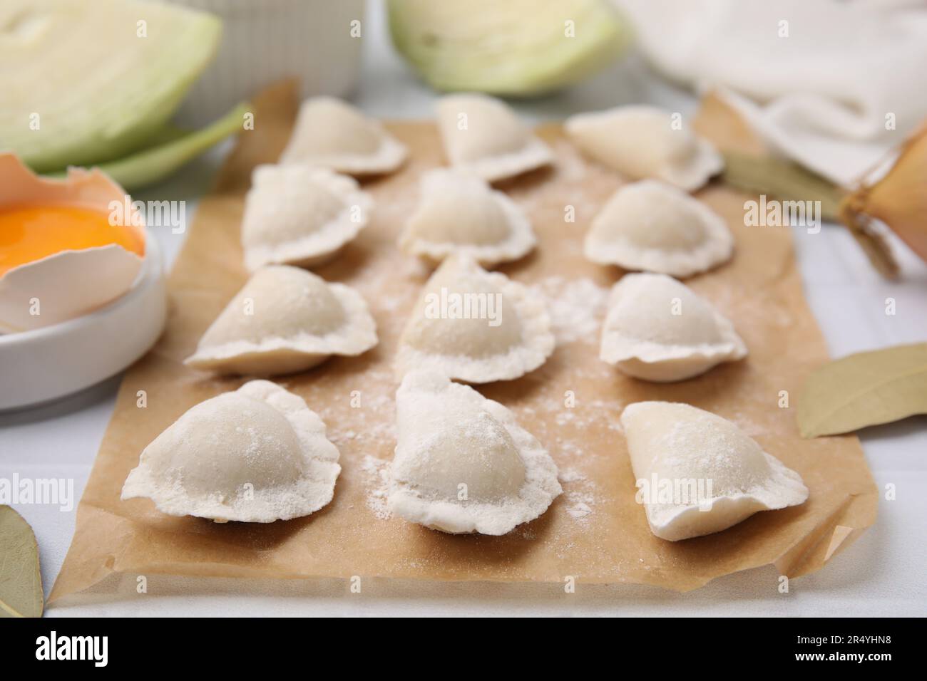 Raw dumplings (varenyky) with tasty filling and flour on parchment