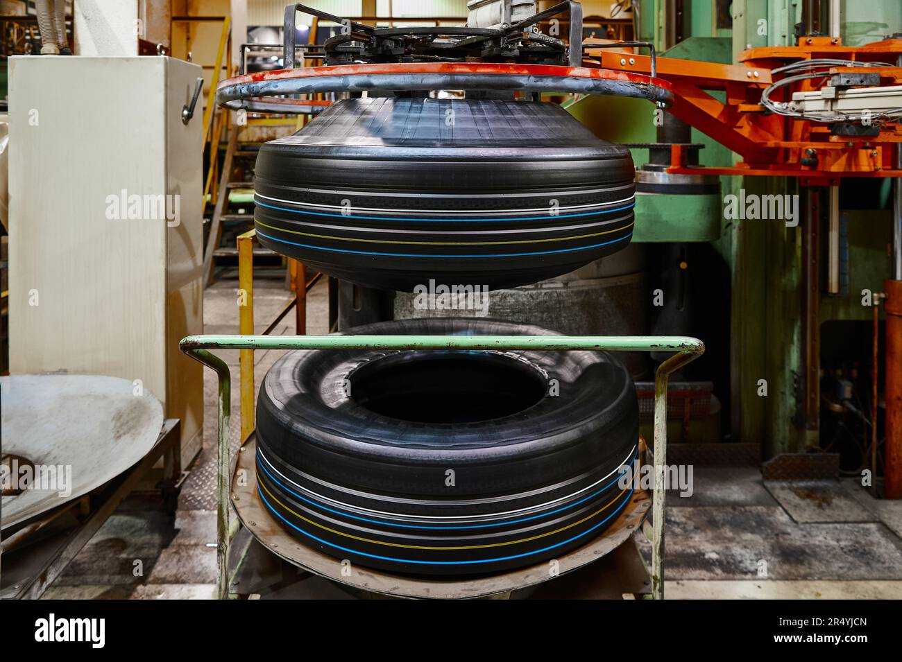 Huge raw tire before vulcanization process by press machine Stock Photo