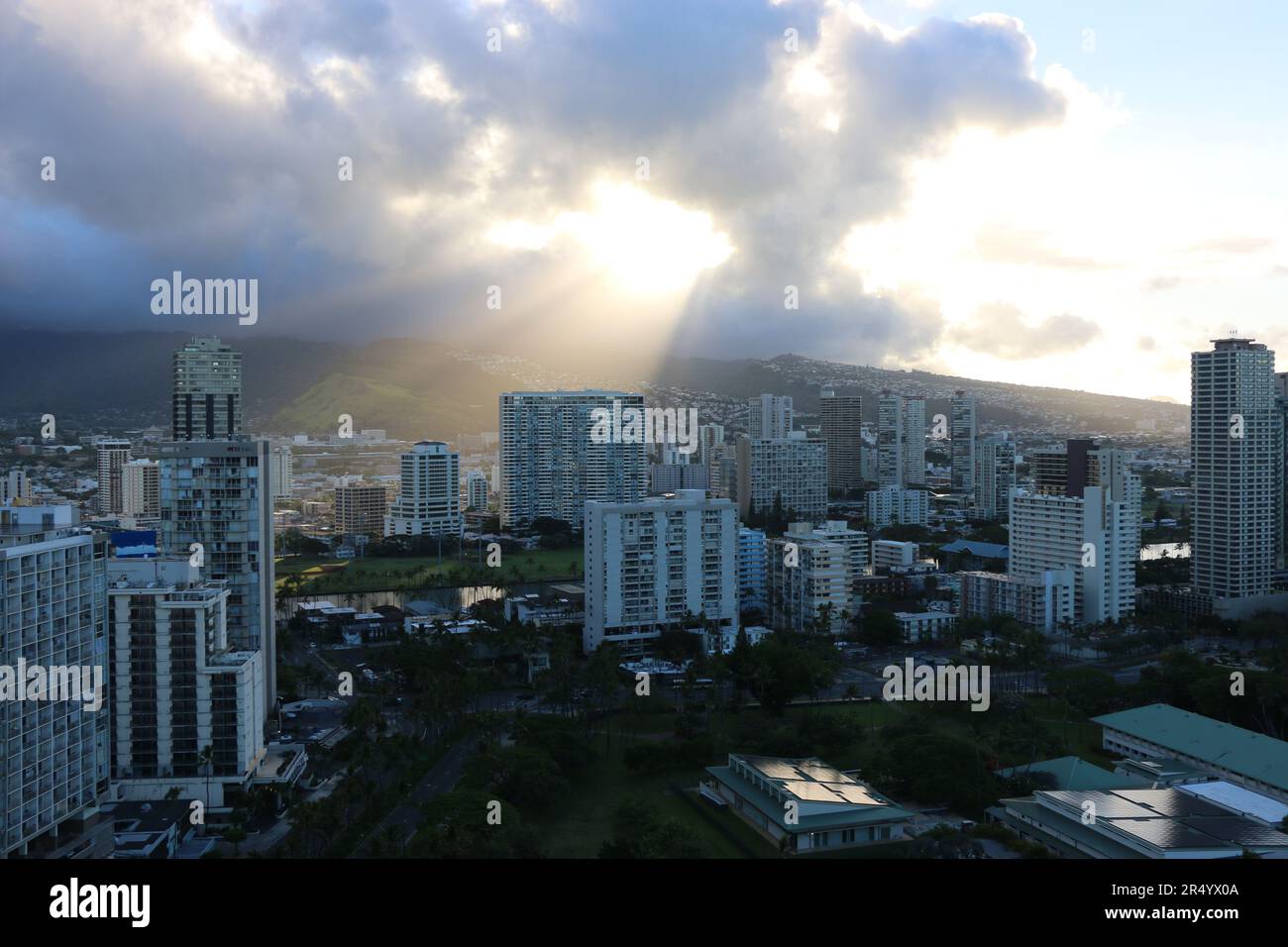 Shafts of golden light at sunrise pierce through the clouds