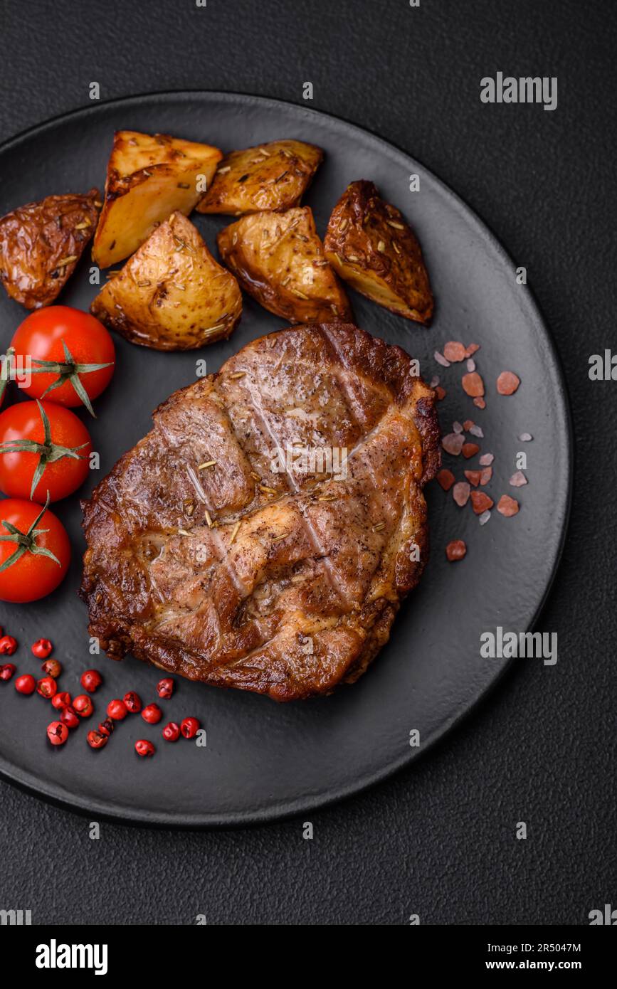 Delicious juicy pork or beef steak grilled with salt, spices and herbs on a textured concrete