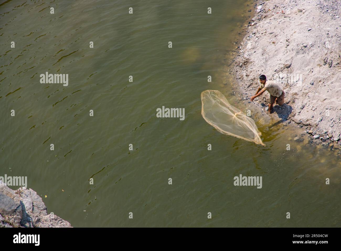 Fisherman throwing net catch fish hi-res stock photography and