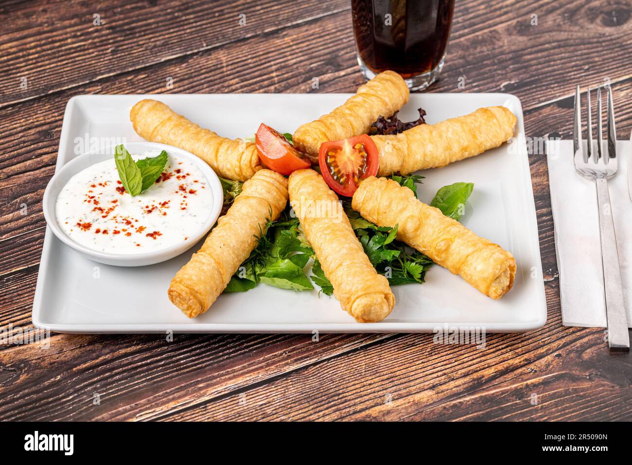 Turkish Cigar Shaped Rolls on a white porcelain plate. The Turkish name is Sigara Boregi Stock Photo