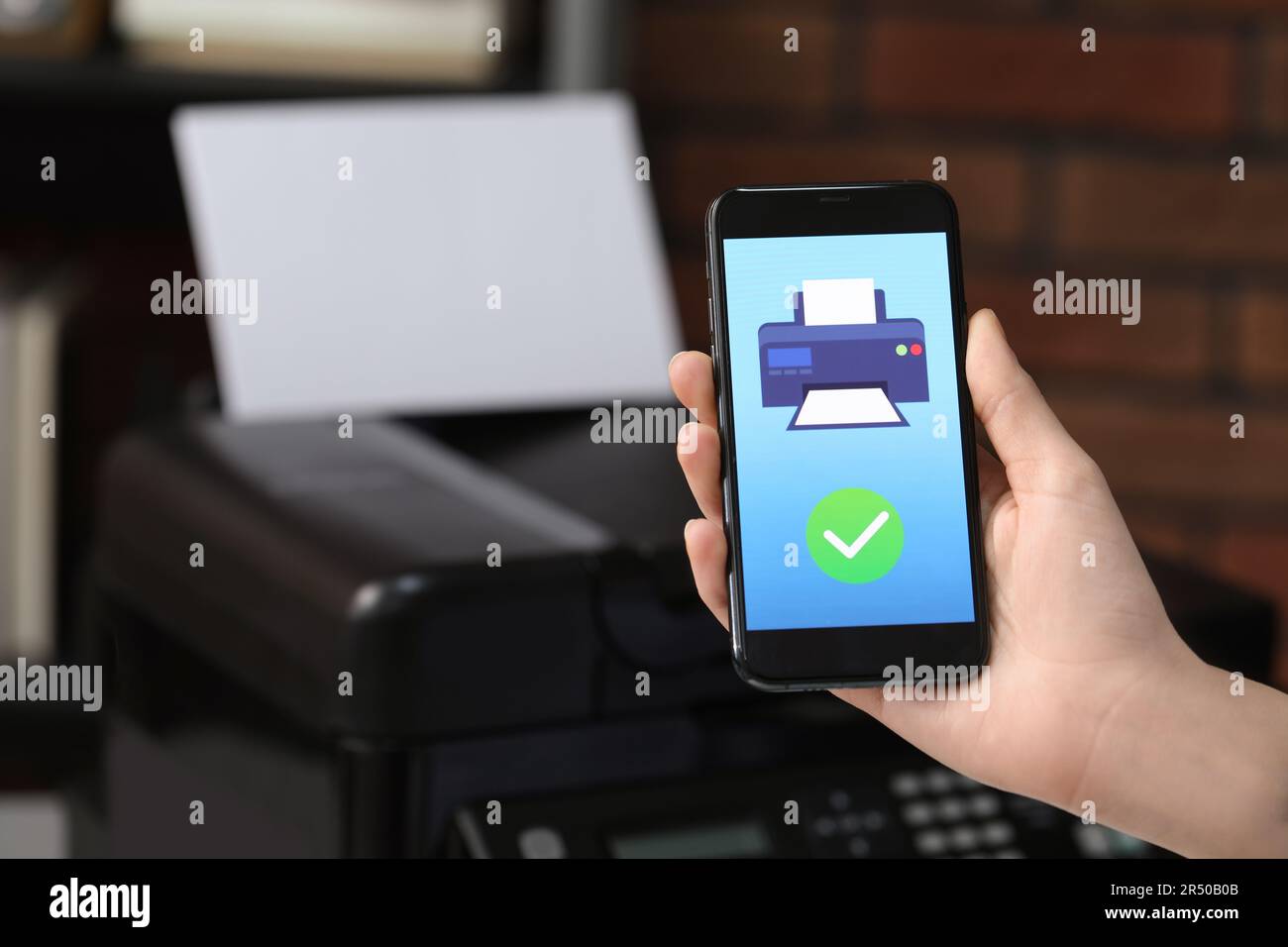 Man using printer management application on mobile phone indoors, closeup and space for text Stock Photo