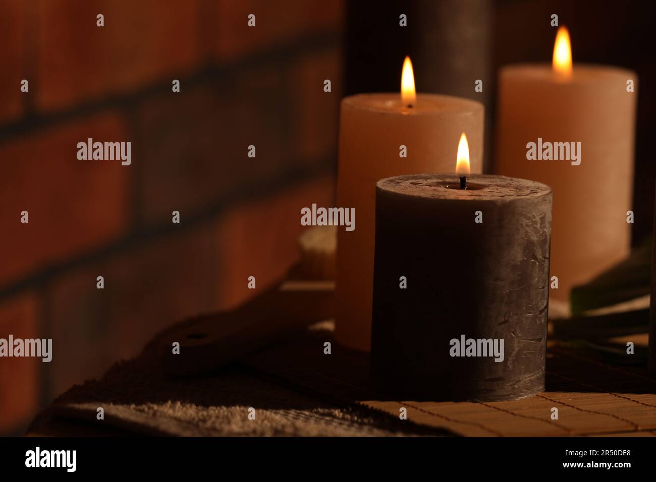 Spa composition with burning candles on massage table in wellness ...