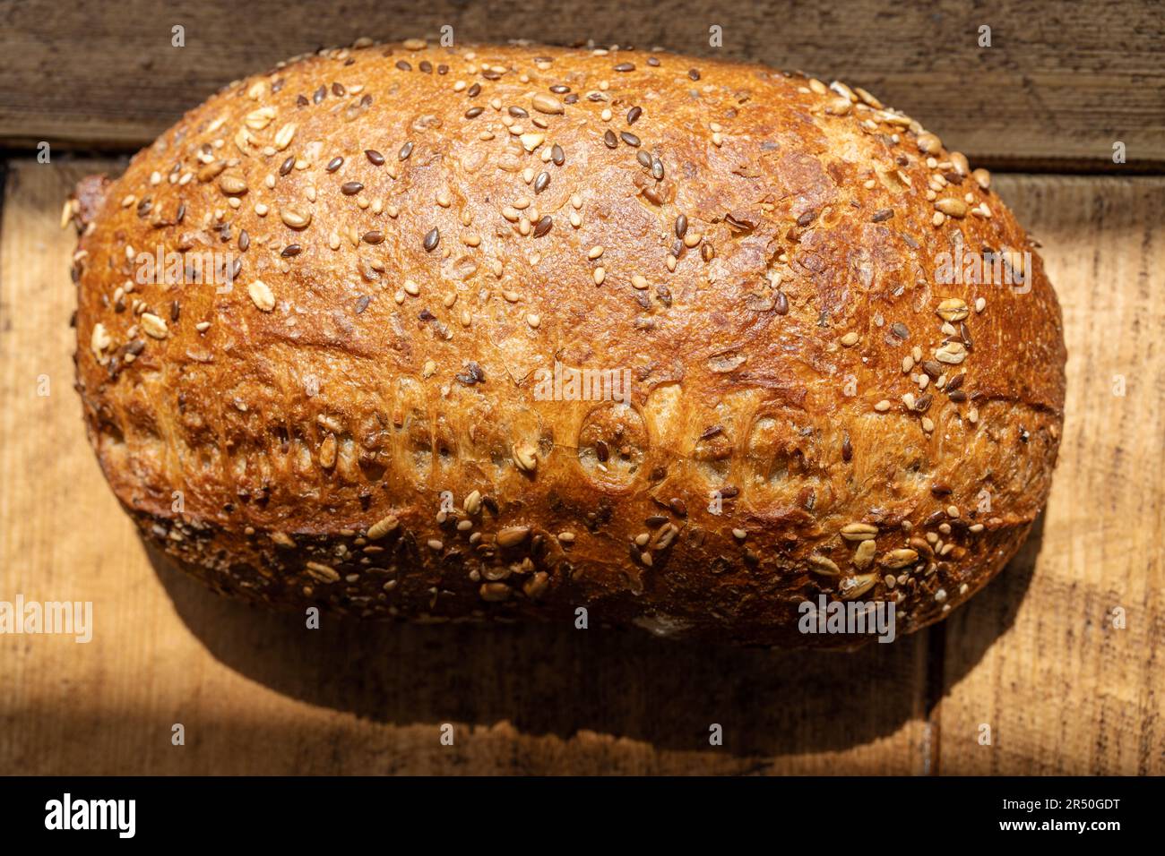 Crusty homemade organic wholegrain bread on a rustic wooden table Stock Photo