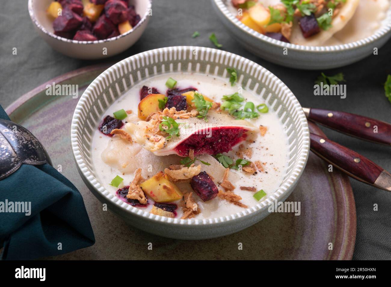 Vegan Swabian ravioli with beetroot filling in creamy sauce with potatoes and beetroot cubes