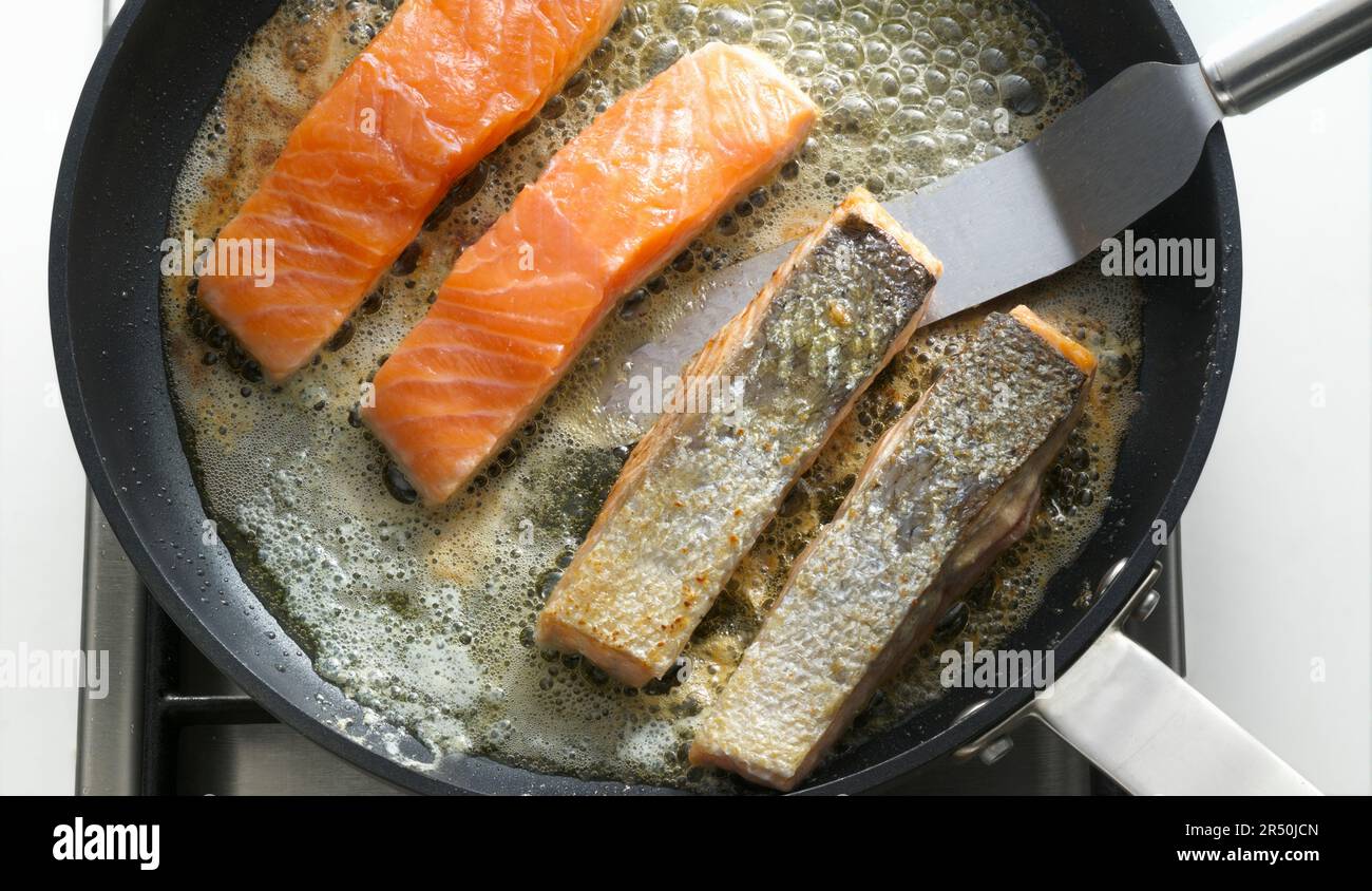 Frying salmon fillets with skin in a pan Stock Photo - Alamy