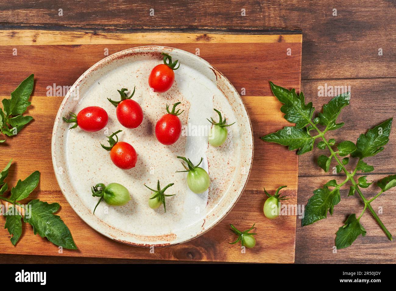 Red and green grape tomatoes on a ceramic plate Stock Photo - Alamy