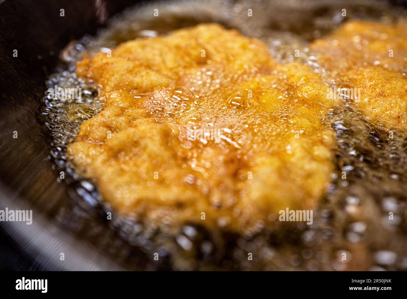 Schnitzel fried in oil in a pan Stock Photo Alamy