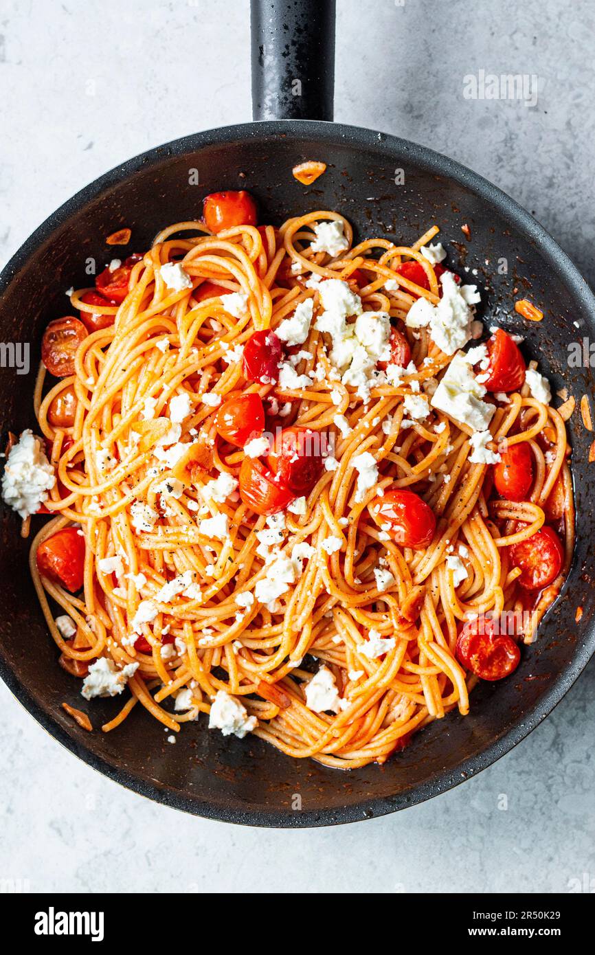 Simple spaghetti 'aglio e olio' with tomatoes and feta Stock Photo Alamy