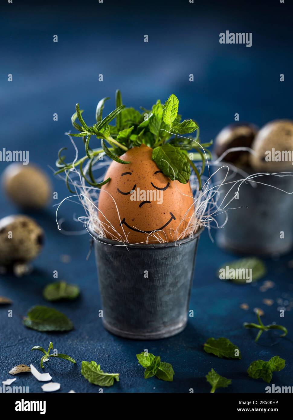 Breakfast egg with a face and herbs in an Easter egg cup Stock Photo