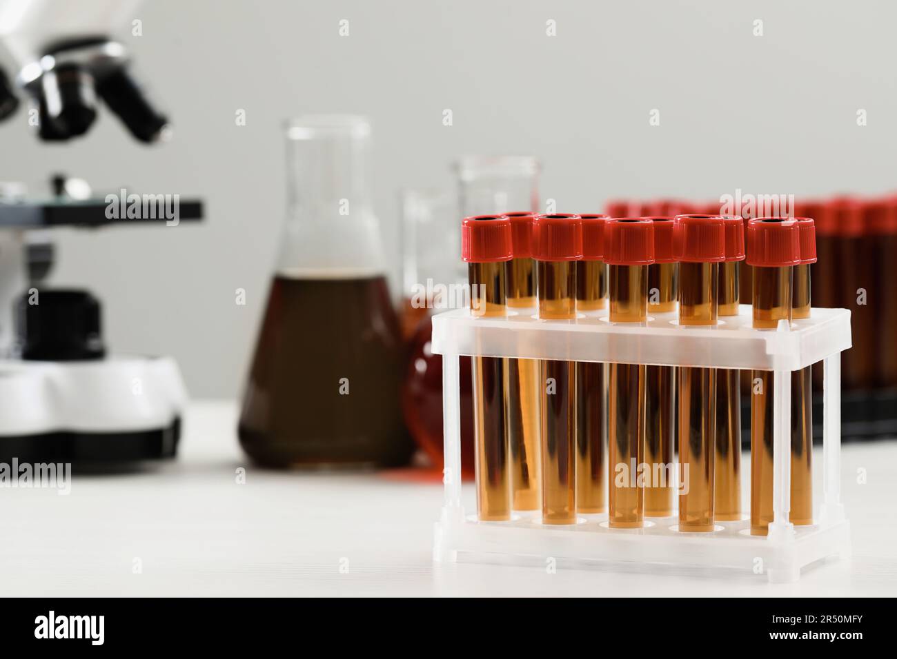 Test tubes with brown liquid on white table. Space for text Stock Photo ...