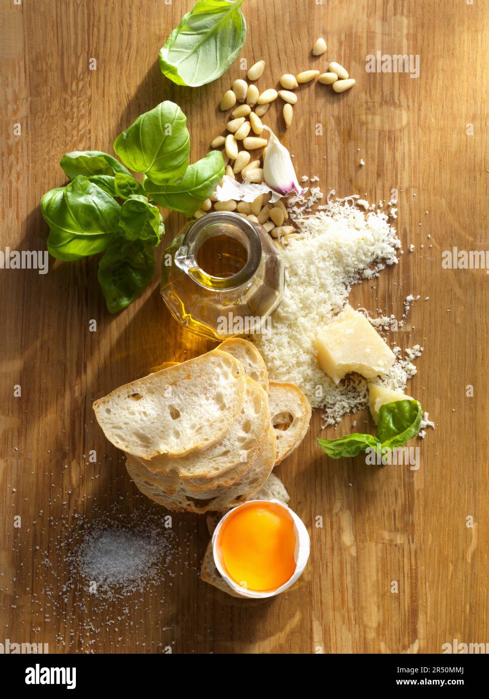 Ingredients for pesto, bread slices, and a broken egg Stock Photo