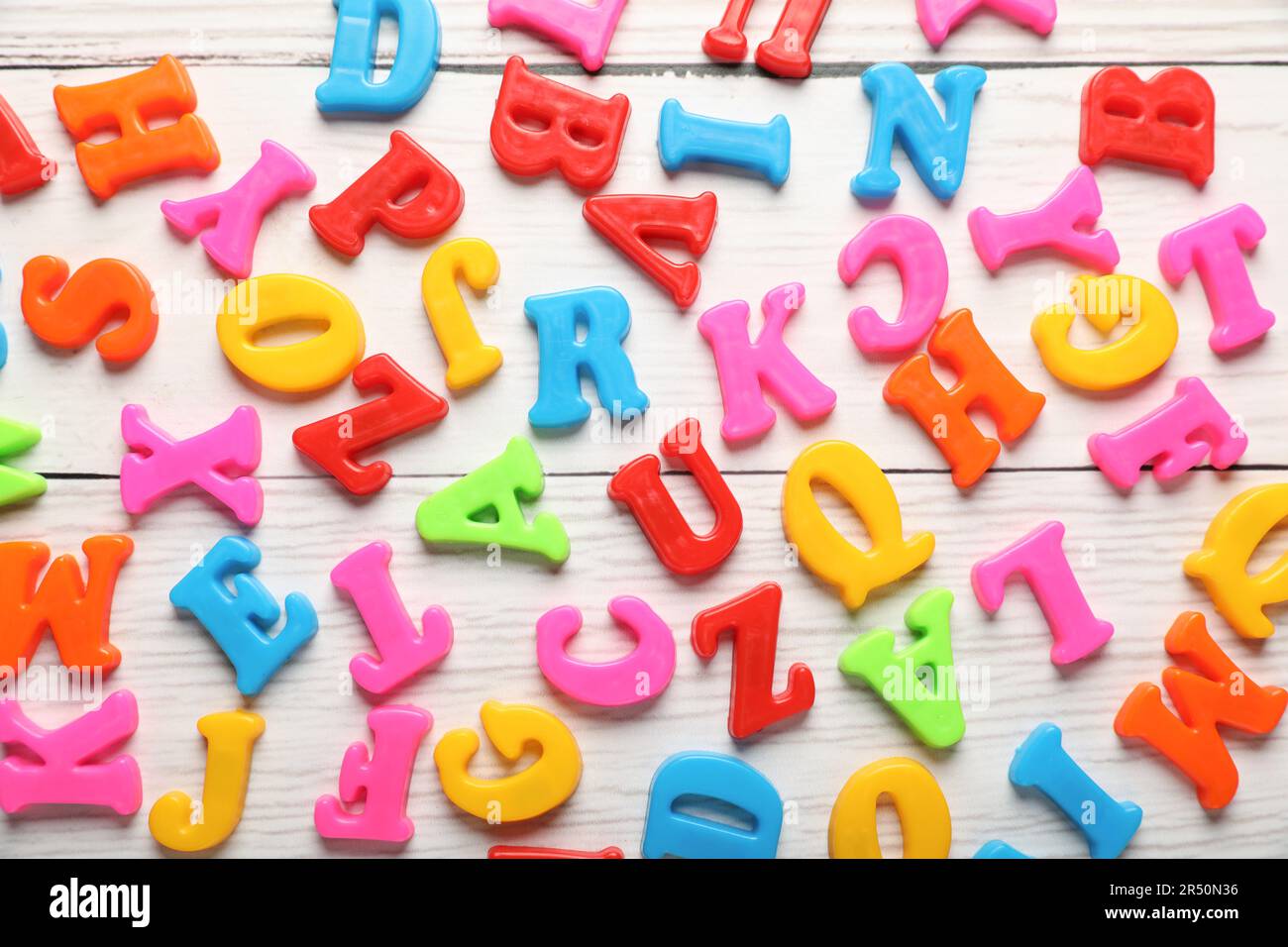 Colorful magnetic letters on white wooden table, flat lay Stock Photo