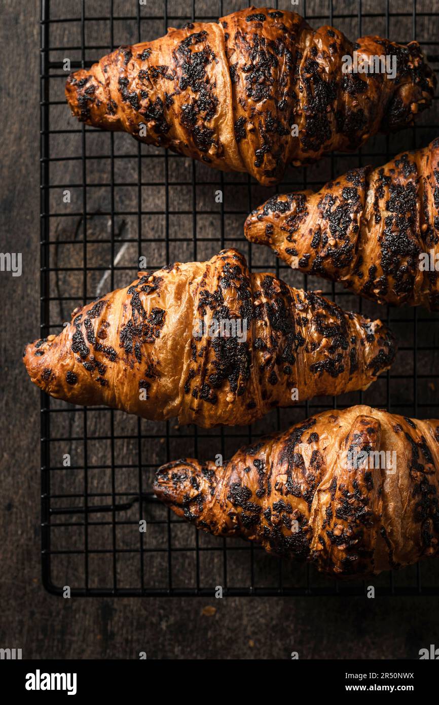 Fresh baked croissants on a baking rack Stock Photo