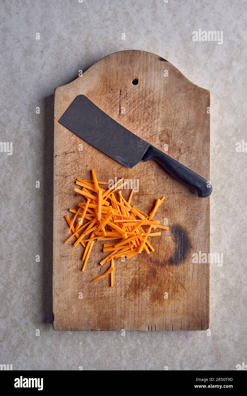 Carrots cut into julienne on wooden board Stock Photo