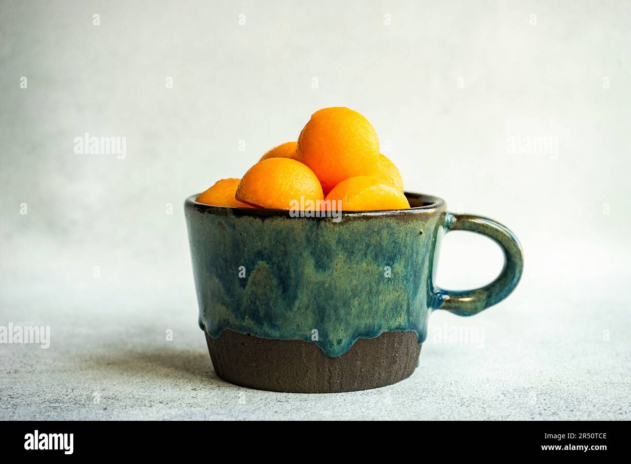 Balls of ripe cantaloupe melon in a ceramic cup Stock Photo