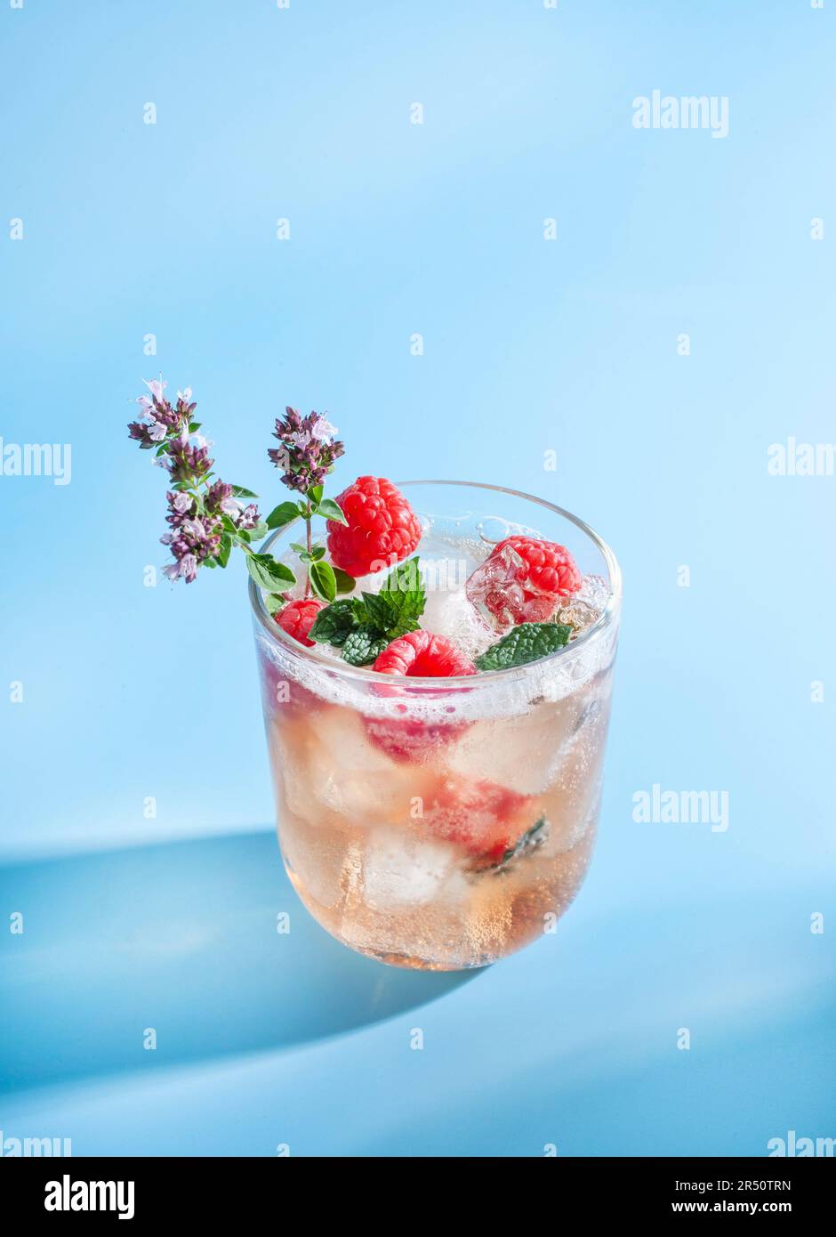 Beer with raspberry juice, ice cubes, and fresh raspberries Stock Photo ...