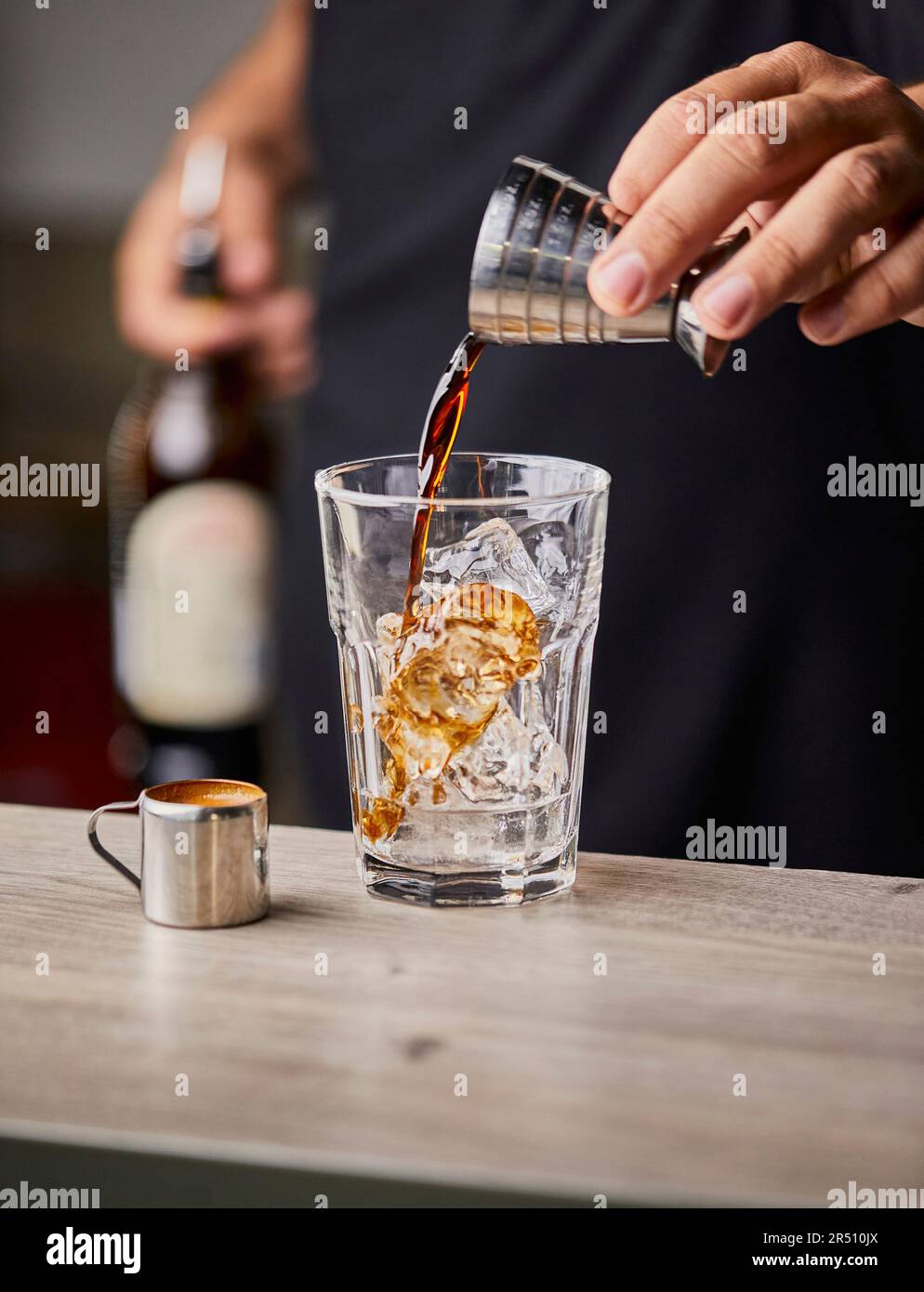 Making Espresso martini, pouring coffee liqueur Stock Photo Alamy