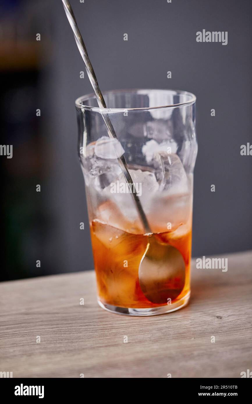 Making Old Fashioned cocktail, mixing with spoon Stock Photo Alamy