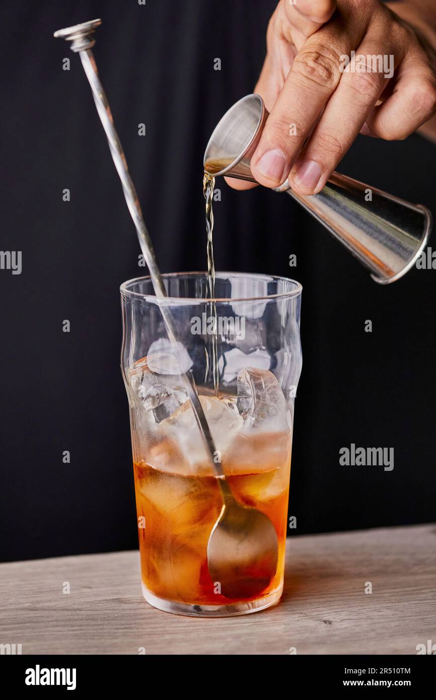 Making Old Fashioned cocktail, adding whiskey Stock Photo Alamy