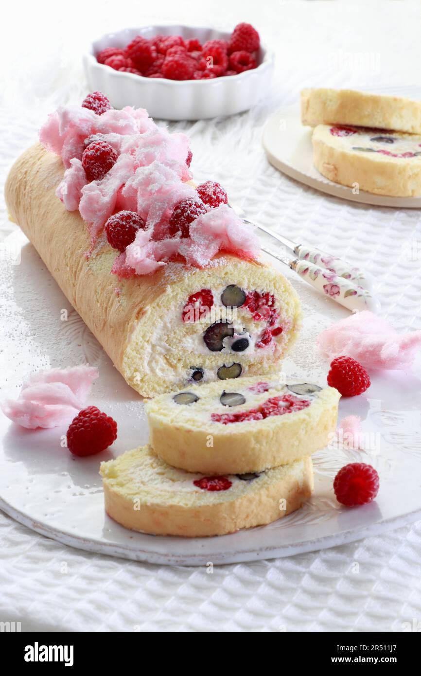 Sponge cake roulade with fresh fruit, decorated with cotton candy Stock