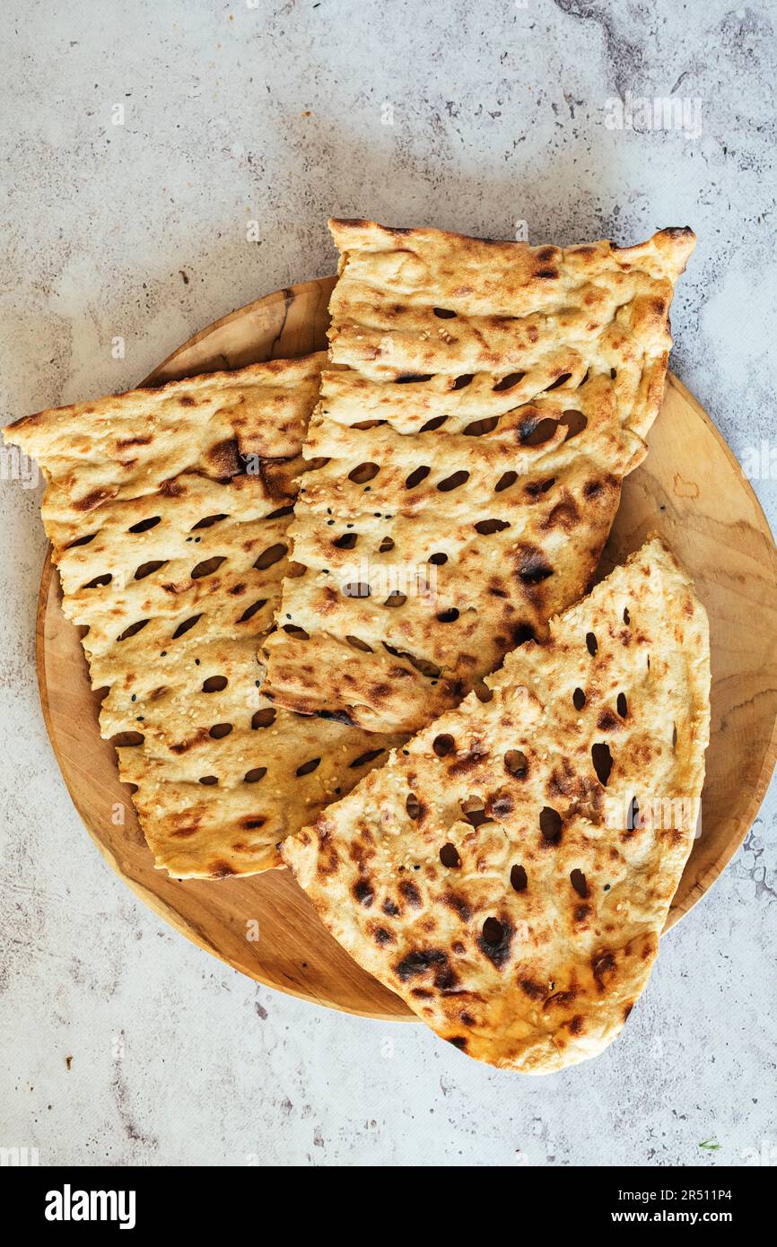 Woman using a dough cutter to divide the naan bread dough into six equal  portions which are flattened and baked. Bakers and pas Stock Photo - Alamy