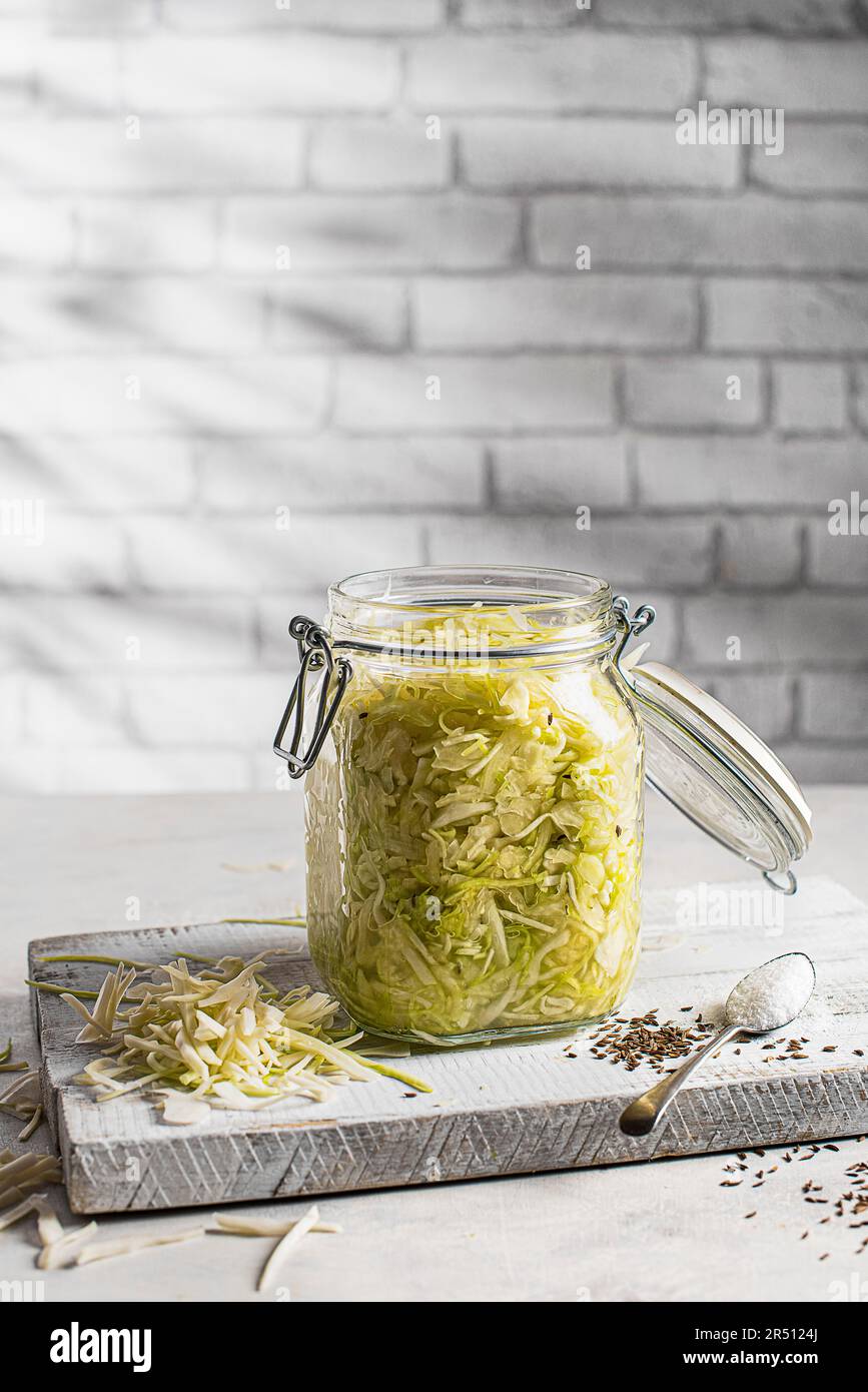 Homemade sauerkraut Salted cabbage with caraway seeds in an iron jar