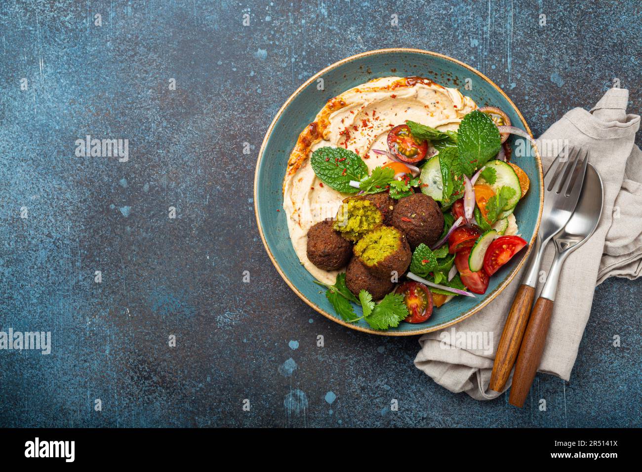 Arab meal with fried falafel, hummus, vegetables salad with fresh green cilantro and mint leaves (Middle Eastern) Stock Photo
