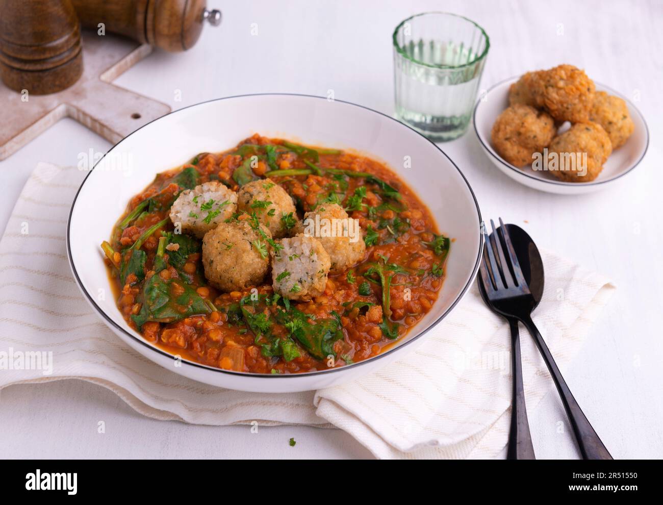 Red lentil dal with spinach and fried rice balls Stock Photo Alamy