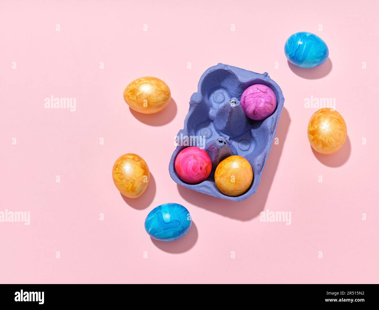 Colourful Easter eggs and egg carton on pink background Stock Photo - Alamy