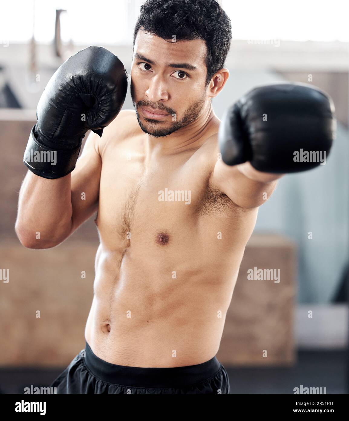 Boxer, portrait and serious man in gym for punch, exercise and training
