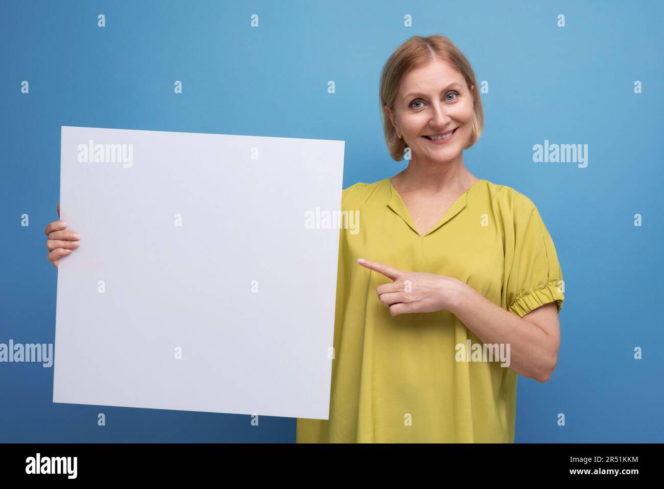 middle aged woman holding poster mockup for information Stock Photo - Alamy