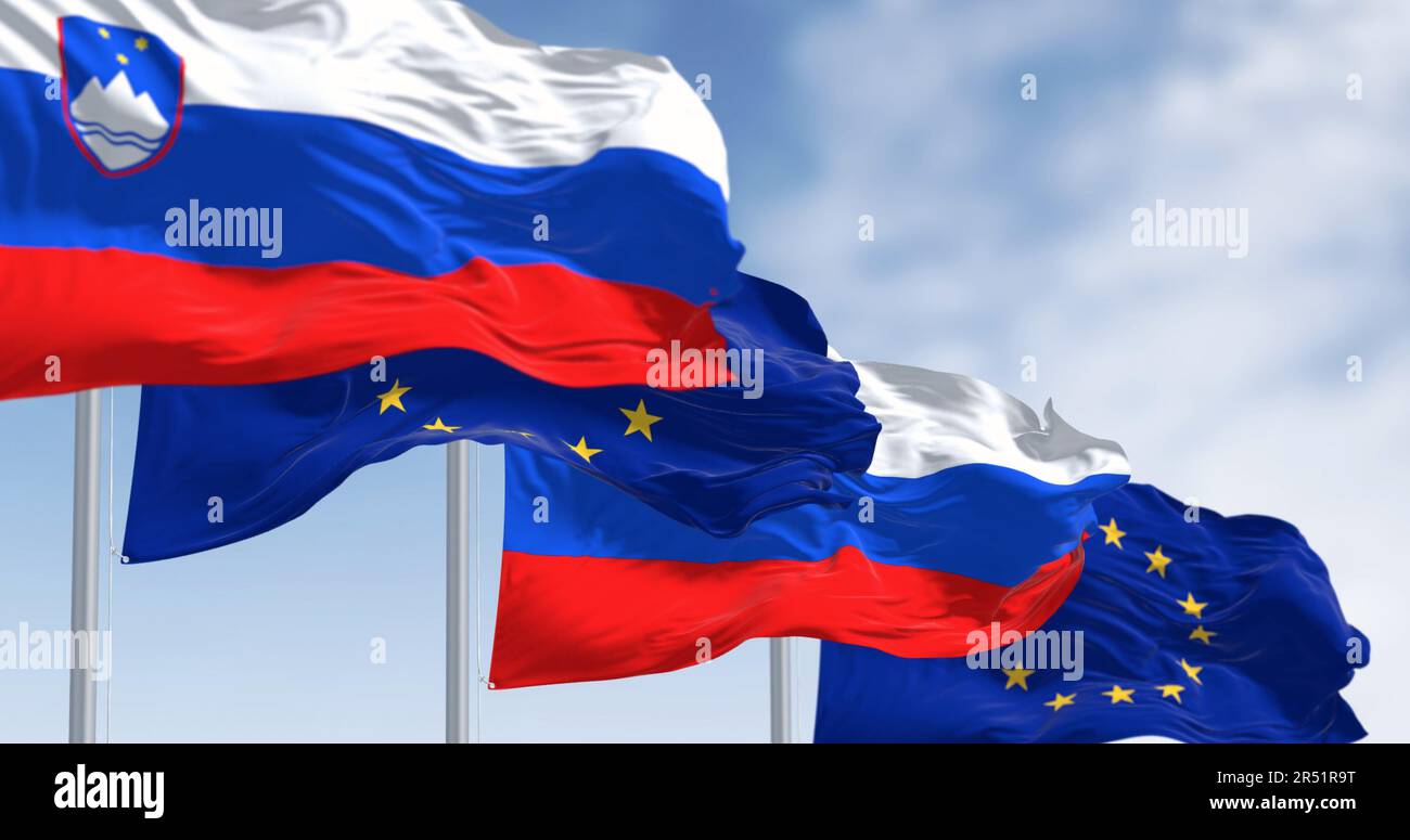 The flags of Slovenia and the European Union fluttering together on a clear day. Slovenia has been a member of the eurozone since January 1, 2007. Stock Photo