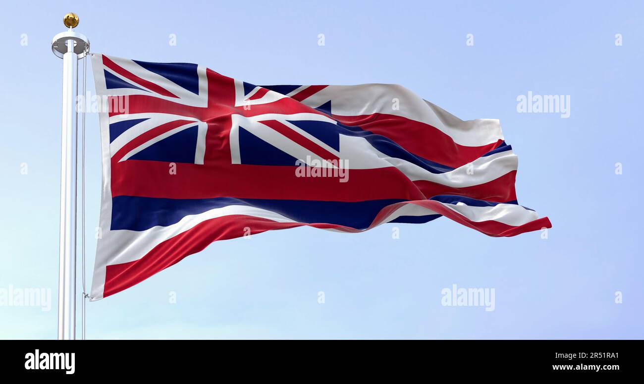 The flag of Hawaii waving in the wind on a clear day. Eight horizontal