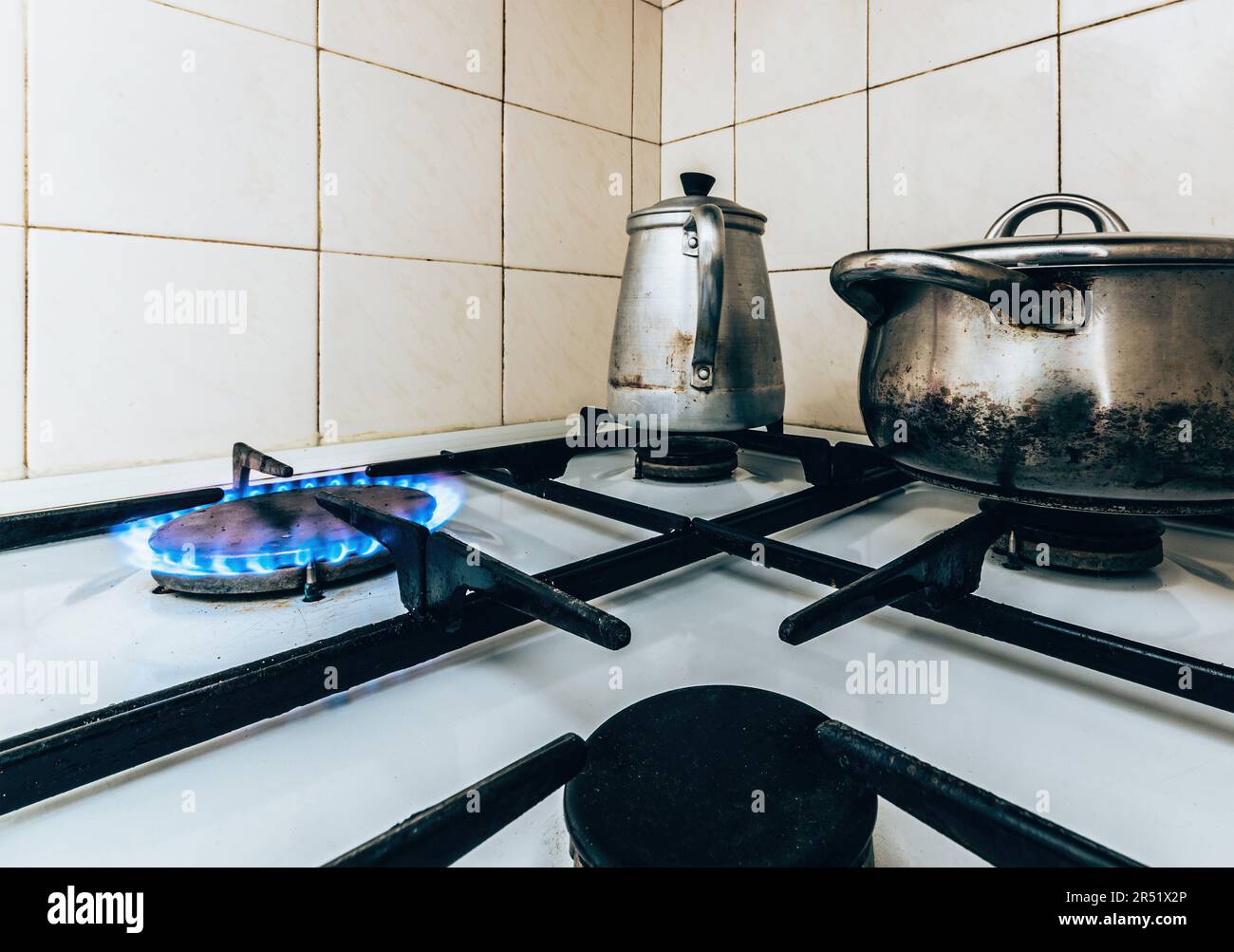 Natural gas burning on stove with pots and pans in the kitchen Stock