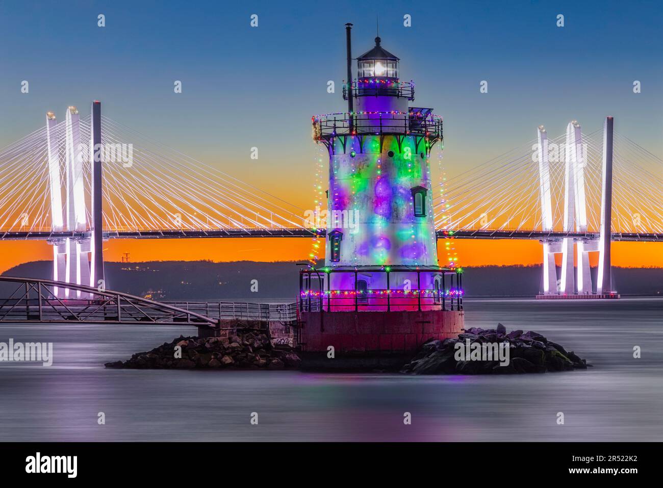 NY Tarrytown Lighthouse - Illuminated with Christmas holiday decorations with the Tappan Zee Bridge, officially named the Governor Mario M. Cuomo Brid Stock Photo