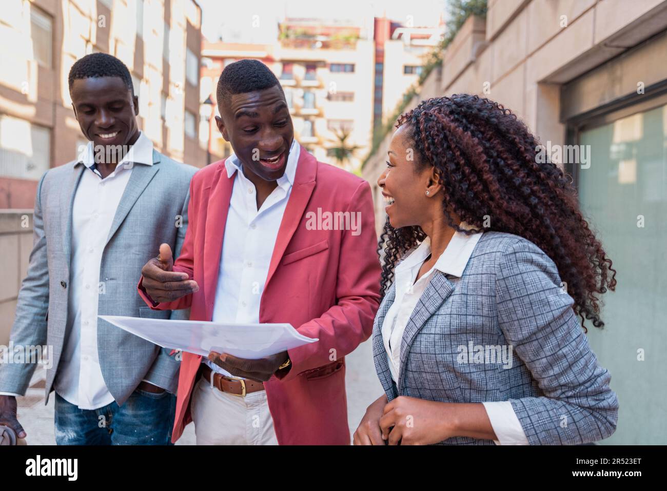 Cheerful African American Male And Female Colleagues In Elegant Outfits Smiling And Looking At