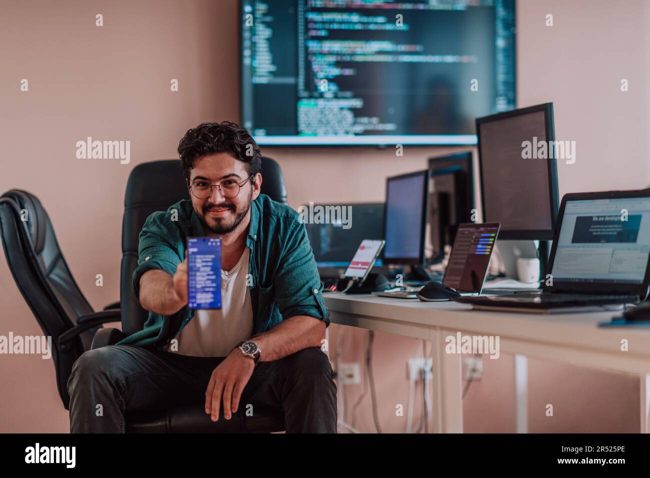 Smartphone Programmer A programmer diligently testing smartphone applications while sitting ...